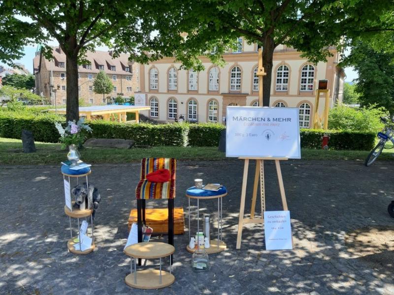 Philipps Erzählplatz auf dem Markt: Stuhl, Koffer und Schild, bevor die Gäste kommen